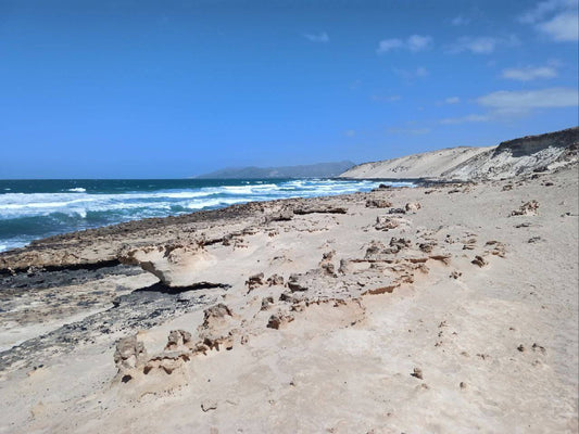 Breathtaking view of Playa de Aqua Liques, showcasing rugged cliffs and crystalline waters along Fuerteventura's West Coast.