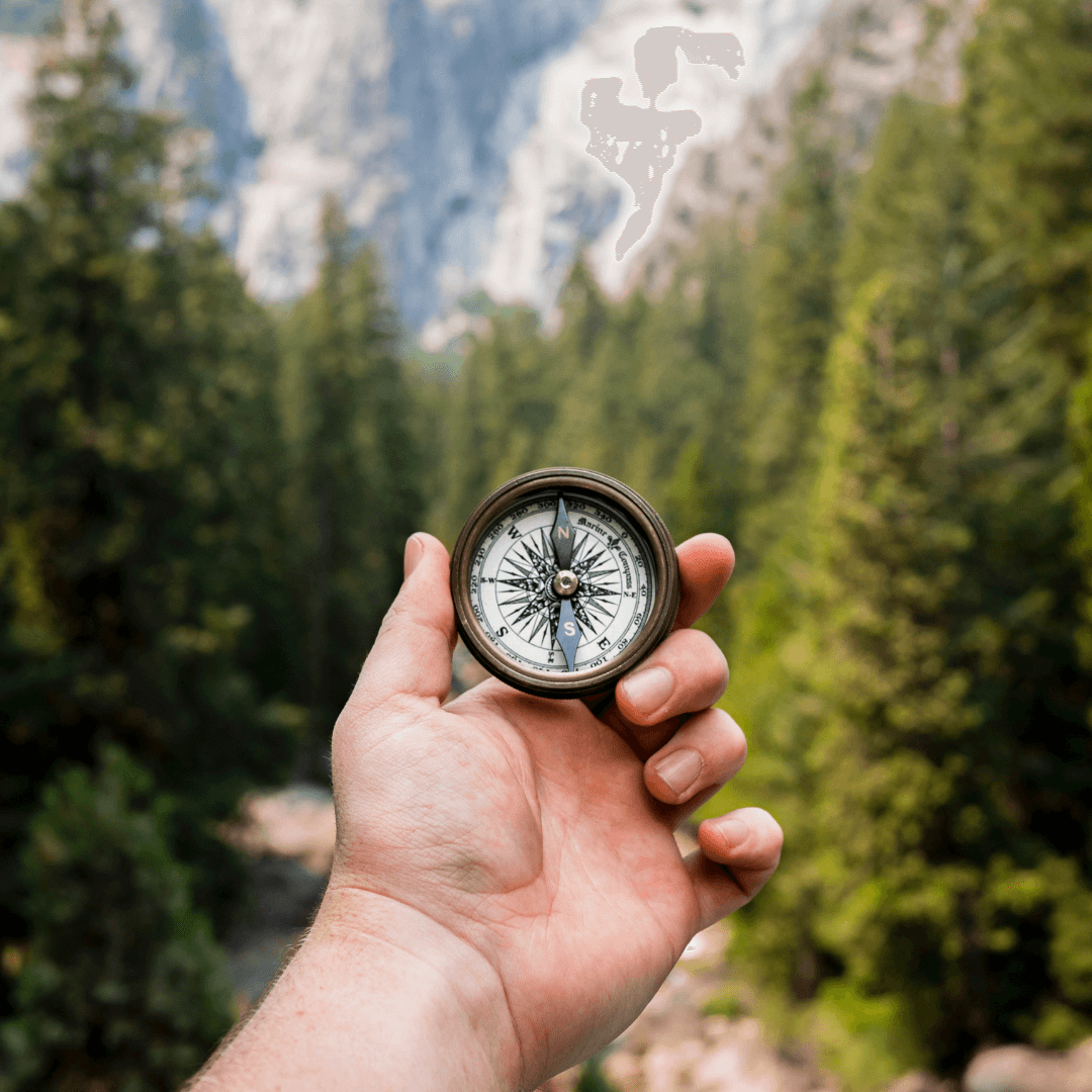 Lost hiker using a compass to find his way back on a cloudy day