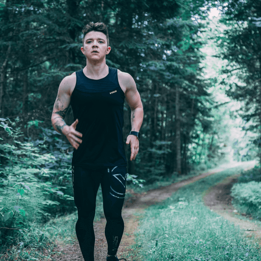 Fit jogger running through forest during outdoor workout