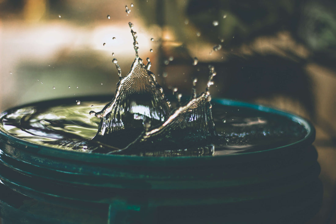 A drop of water is dropping into a cup of water