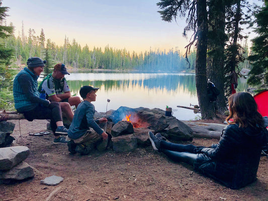 Family enjoying a peaceful evening by the campfire during a camping trip in the great outdoors