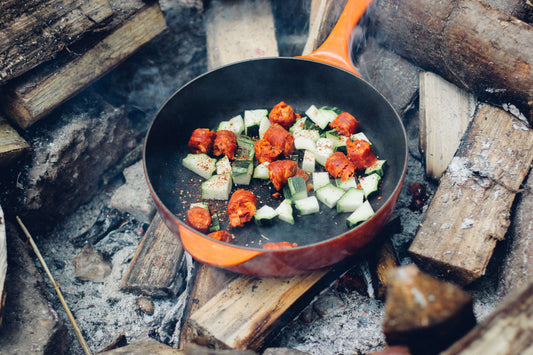A delicious meal being cooked to perfection over a crackling campfire surrounded by nature