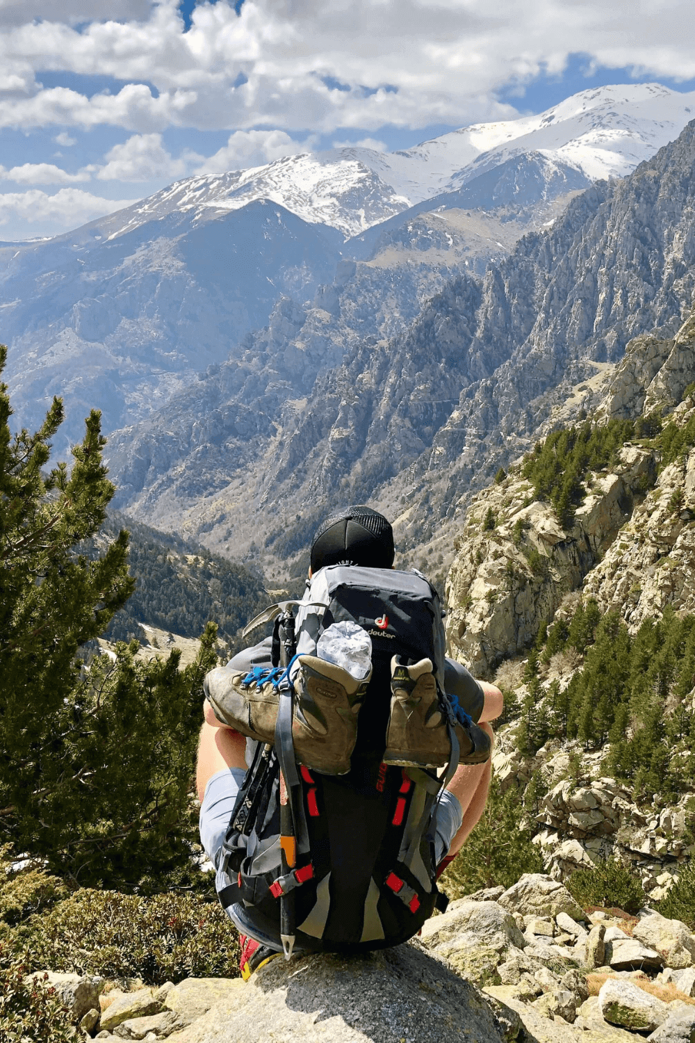 Hiker taking a break and enjoying the scenic view of a majestic canyon, highlighting the beauty of nature and outdoor adventure.