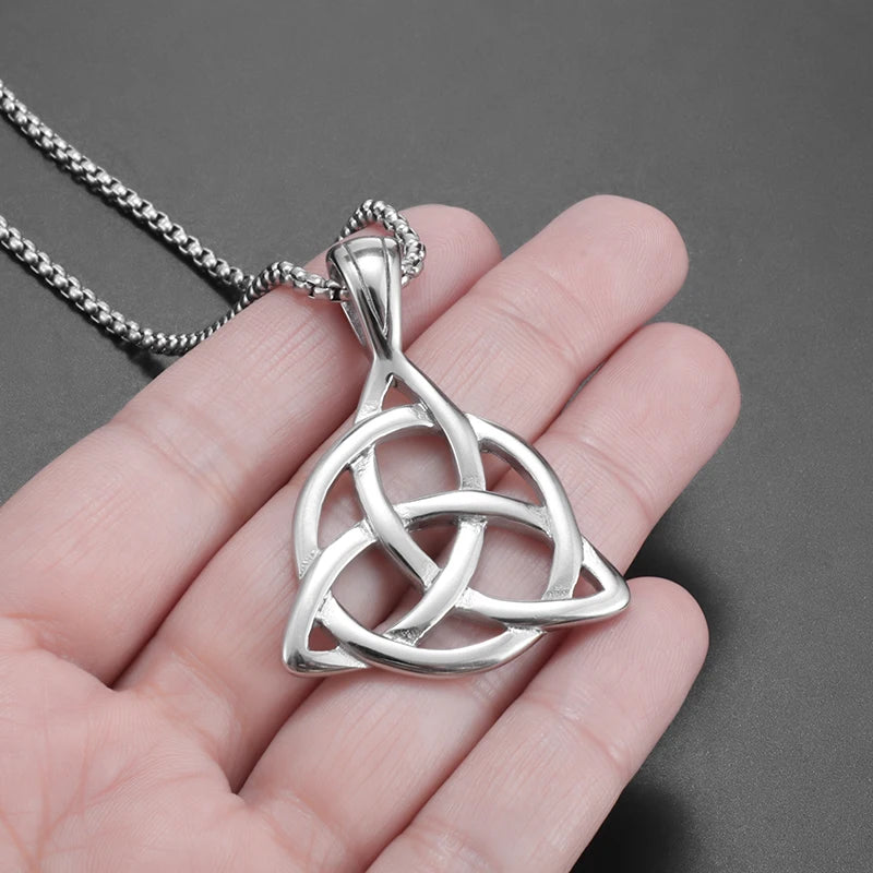 Artistic shot of the Celtic Trinity Knot Necklace laid out on a rustic wooden surface, emphasizing the cultural and historical significance of the pendant.