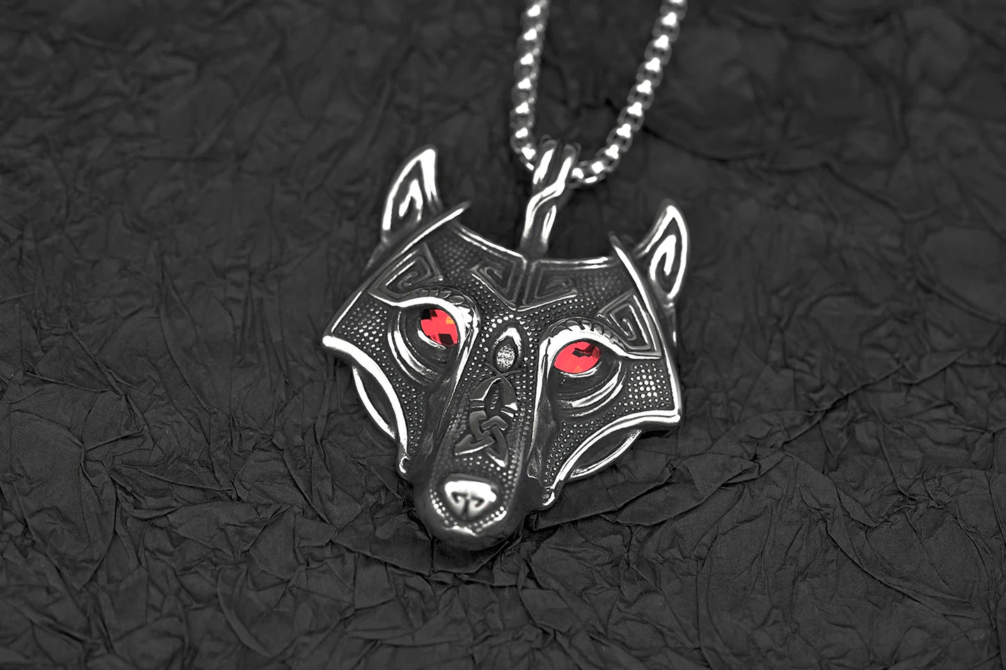 Elegant shot of the Fenris Wolf pendant featuring red glowing eyes, showcased against a dark background to emphasize its mystical allure.