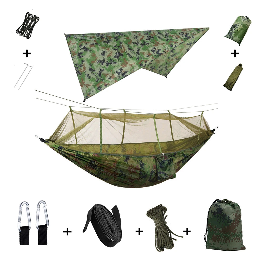 Aerial view of the EverShield Expedition Hammock set up by a lakeside, capturing the full setup with rain tarp and mosquito net in a scenic outdoor location.