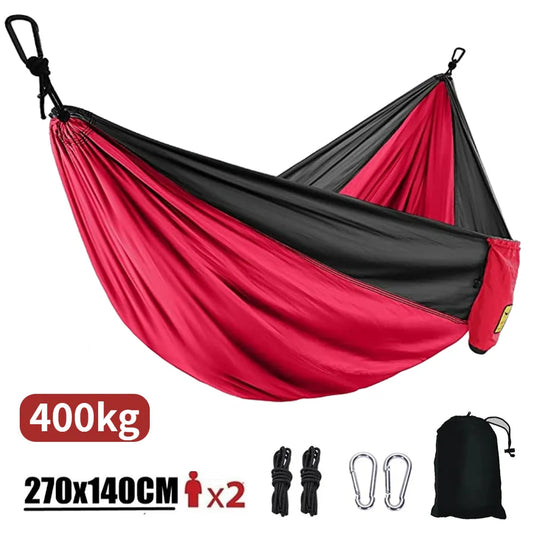 SkyNest Adventure Hammock set up between two trees in a lush forest, showcasing its spacious and durable parachute nylon fabric.