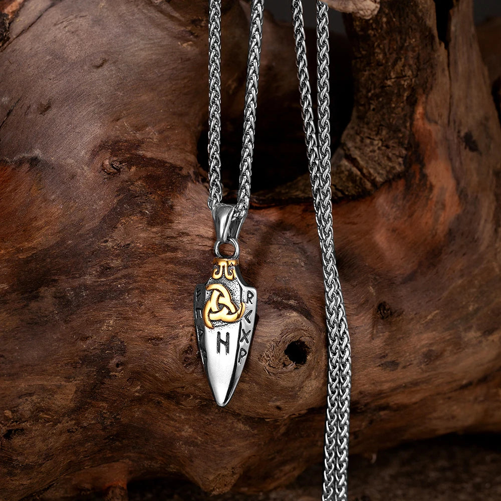 Artistic shot of the Gungnir Spear Necklace laid out on a wooden surface, emphasizing the 1.65-inch long pendant's fine engraving.