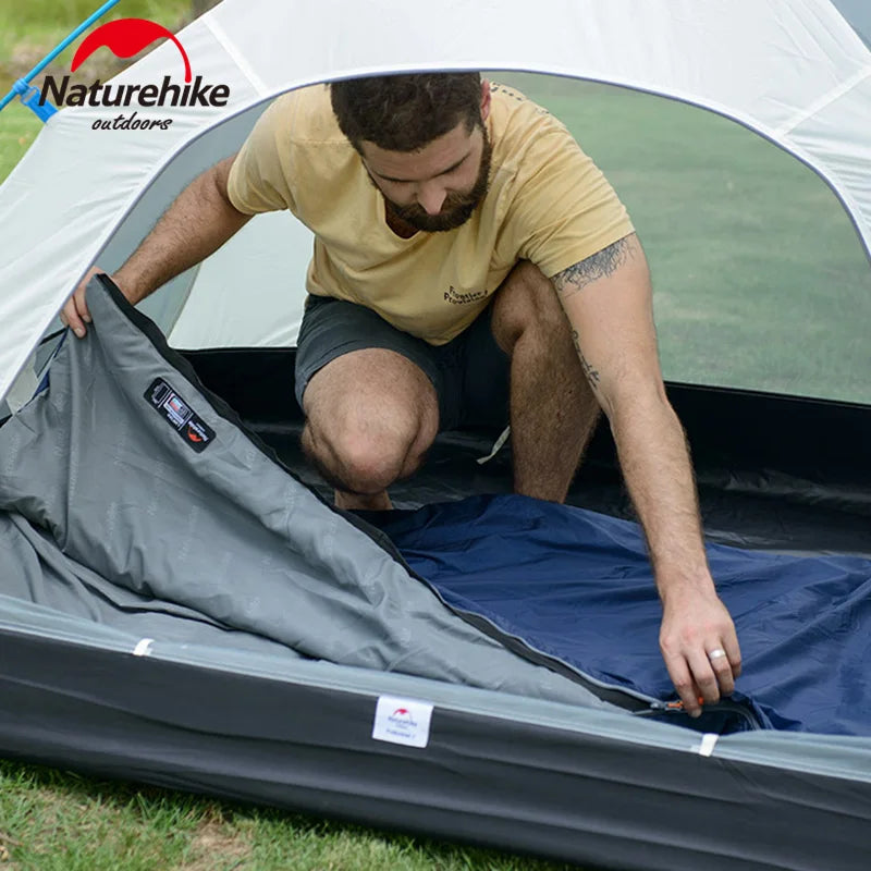 Naturehike Starlite LW180 laid out on grass with the zipper open, emphasizing the envelope style and interior comfort of the sleeping bag.